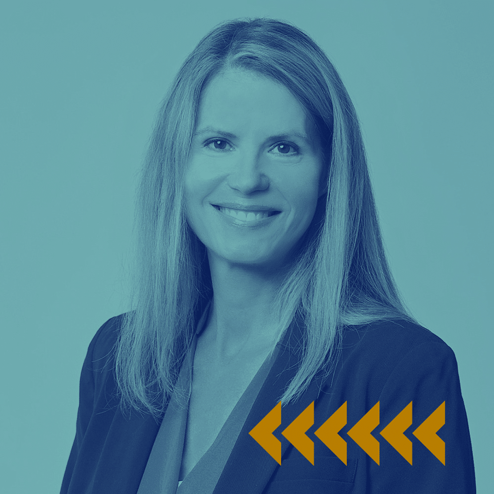 A woman with long, straight hair smiles at the camera, wearing a blazer. The image has a blue tint and five yellow arrow-like shapes are displayed in the lower right corner.